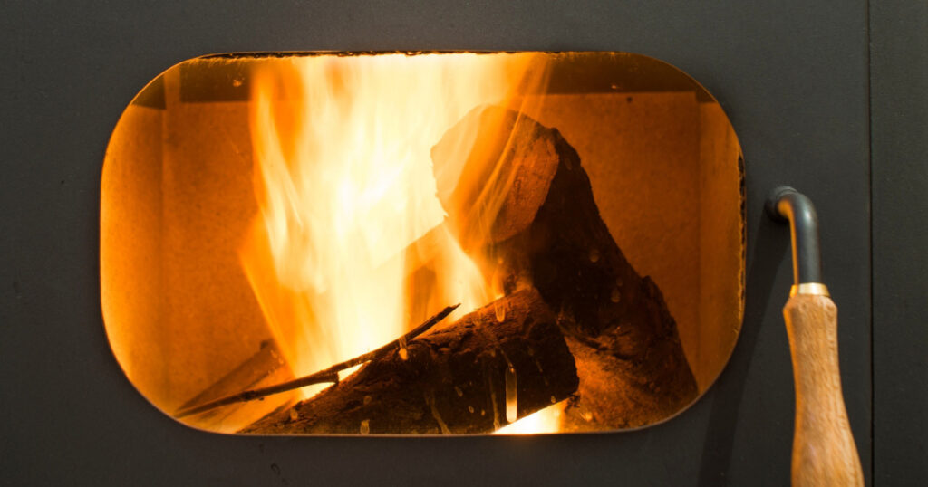 A closeup view of the interior of a lit modern wood stove.